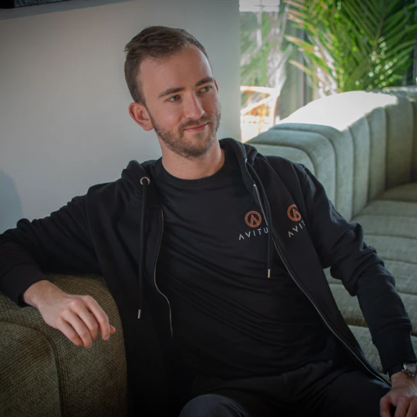 Christoffer, grundare av Avitus IT webbyrå Helsingborg, sitter i en soffa med kläder från Avitus IT