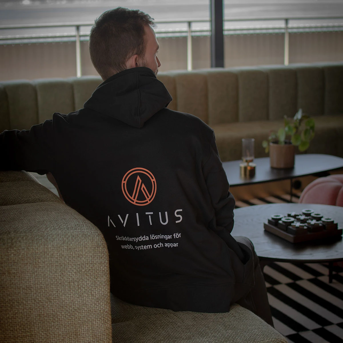 Bild på Christoffer, grundare av Avitus, bakifrån när han har en tröja med texten "Avitus, Skräddarsydda lösningar för webb, system och appar"