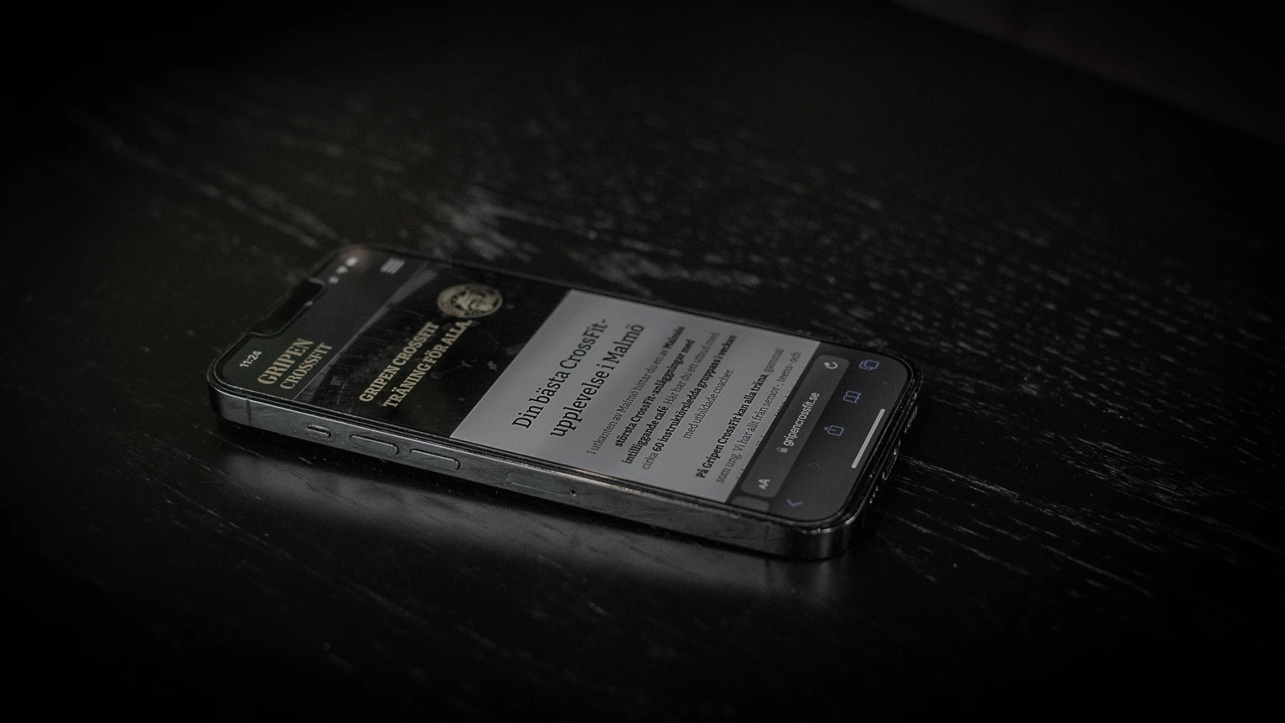 En mobiltelefon på en bänk, med Gripen CrossFits hemsida på den.